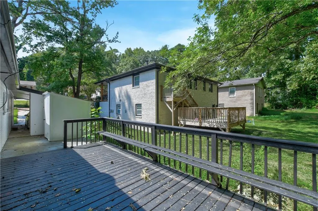 Wooden deck featuring a lawn and view of scattered trees