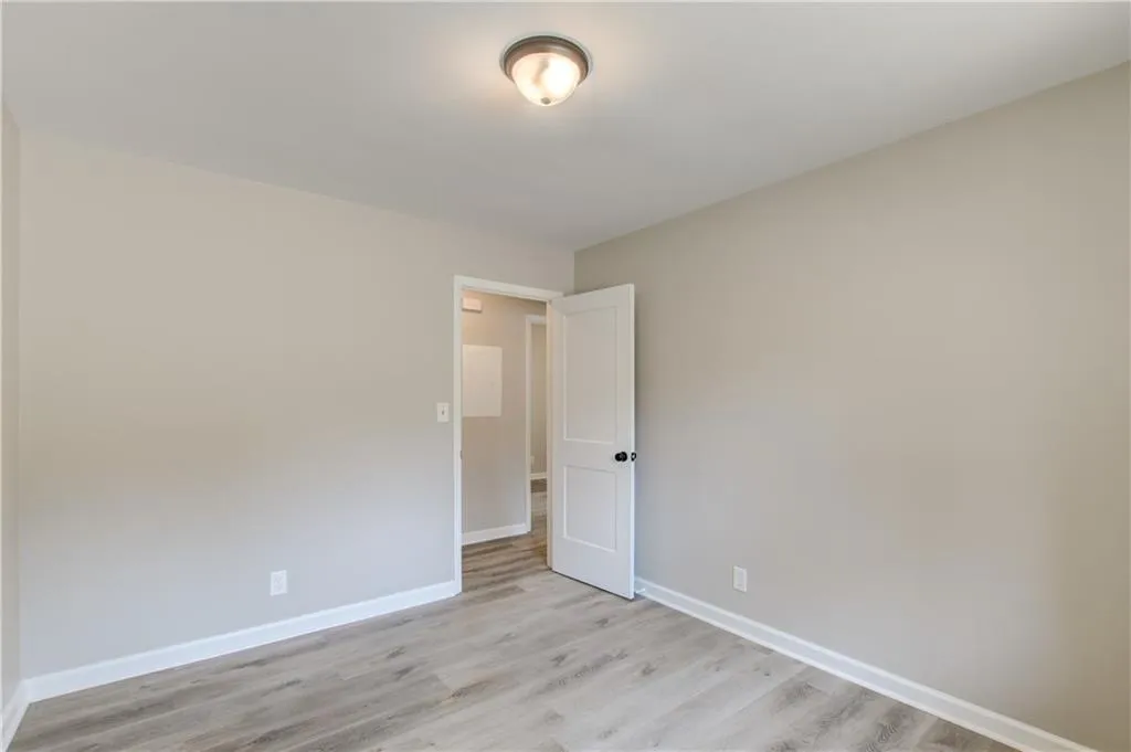 Spare room featuring light wood-style flooring and baseboards