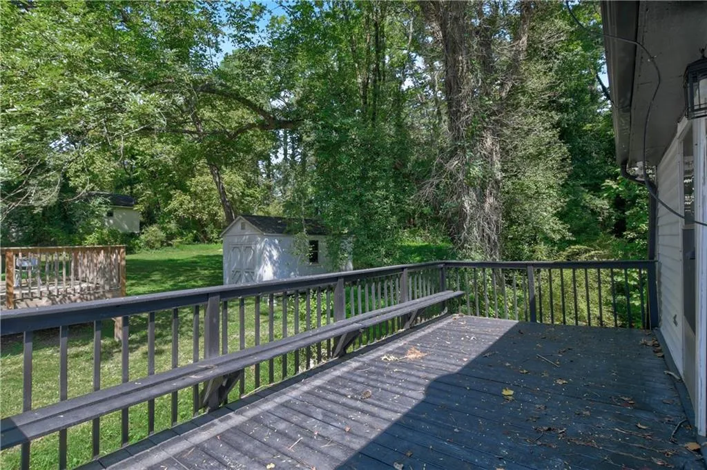 Deck featuring a storage shed and view of scattered trees