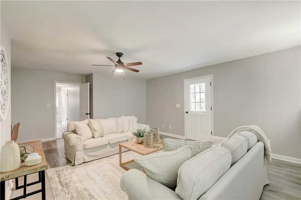 Living area with ceiling fan and light wood-style floors