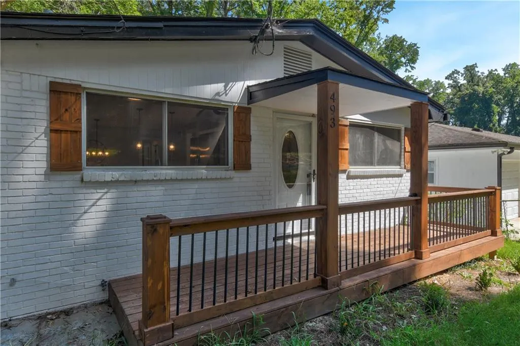 View of property exterior featuring brick siding and a wooden deck