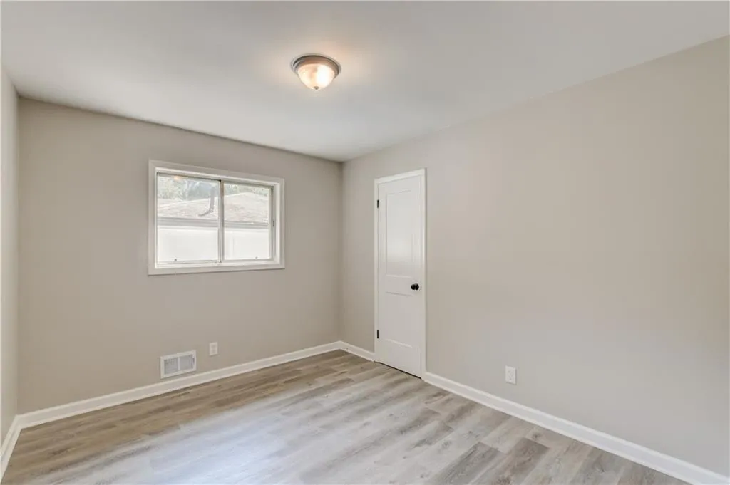 Unfurnished room with light wood-type flooring and baseboards