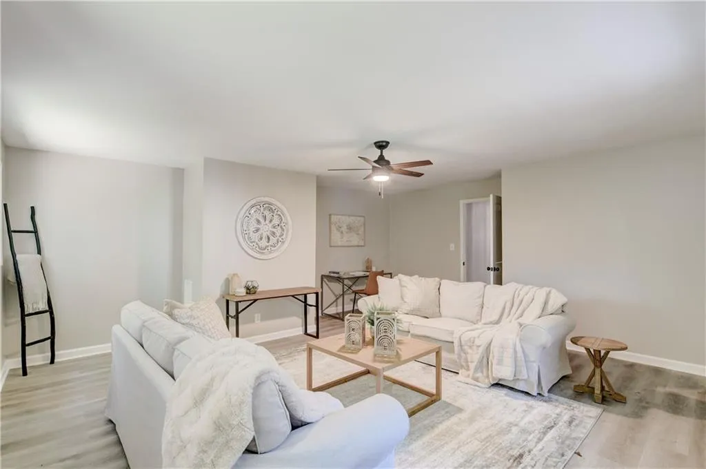 Living area with light wood-style flooring and a ceiling fan