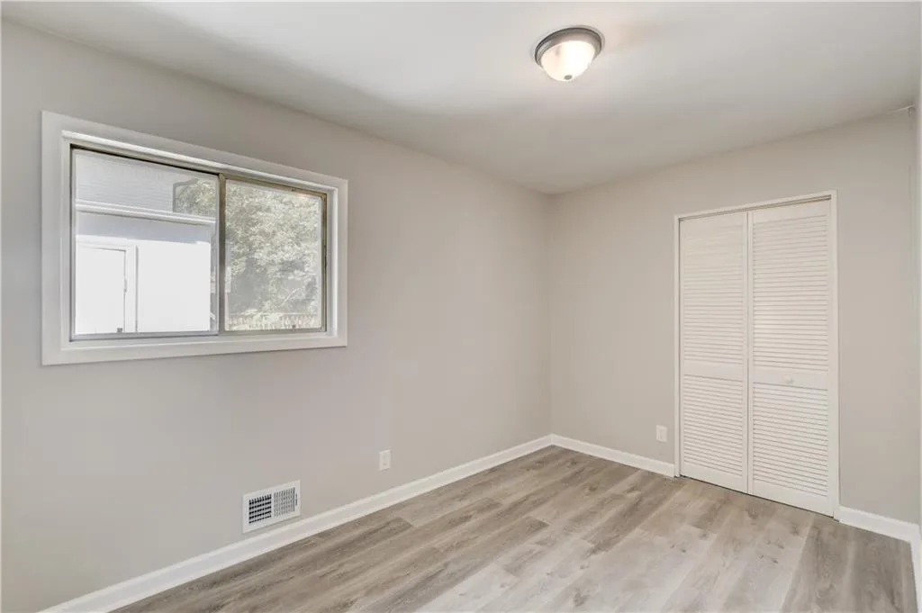 Unfurnished bedroom with light wood-style floors and a closet
