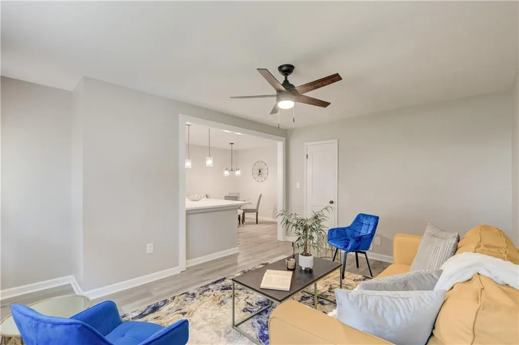 Living area featuring wood finished floors and a ceiling fan