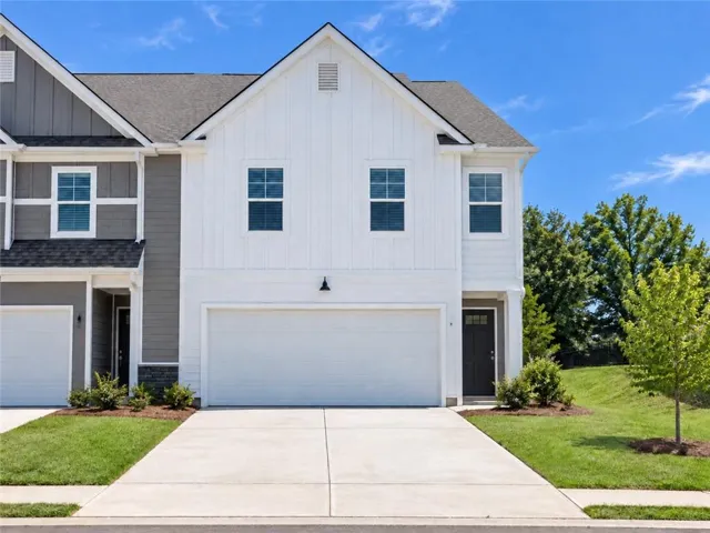 Contemporary exterior with white board-and-batten siding and dark trim accents