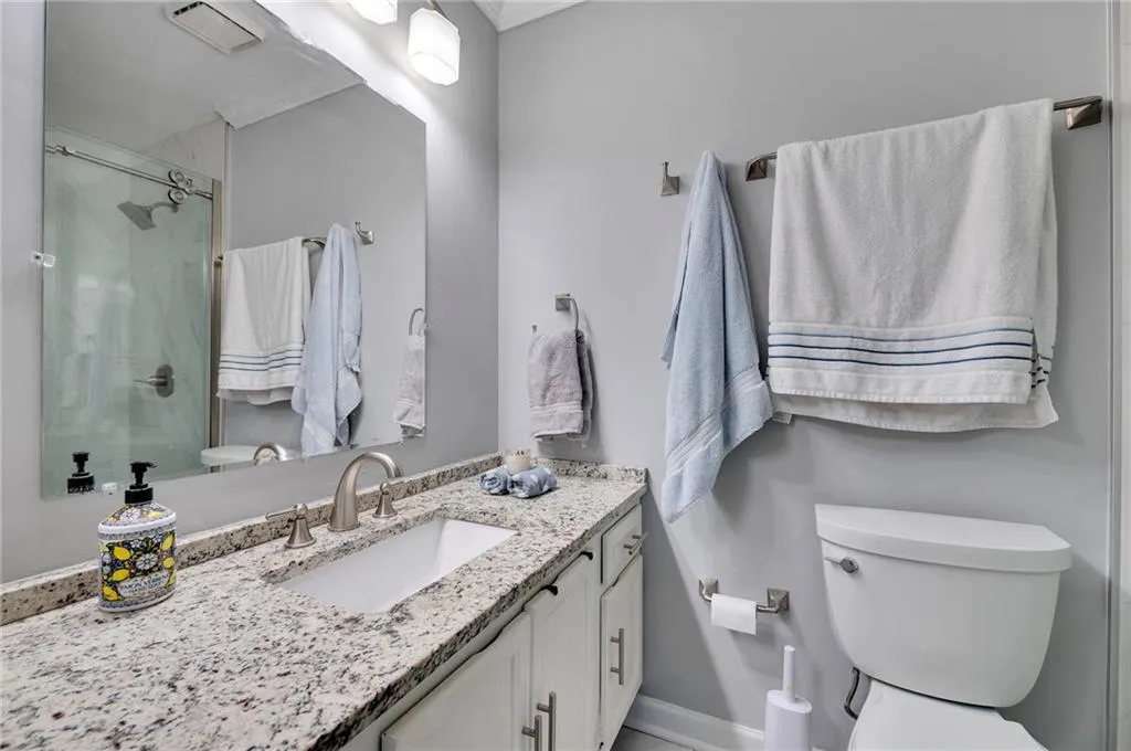 Bathroom with walk in shower, toilet, and vanity