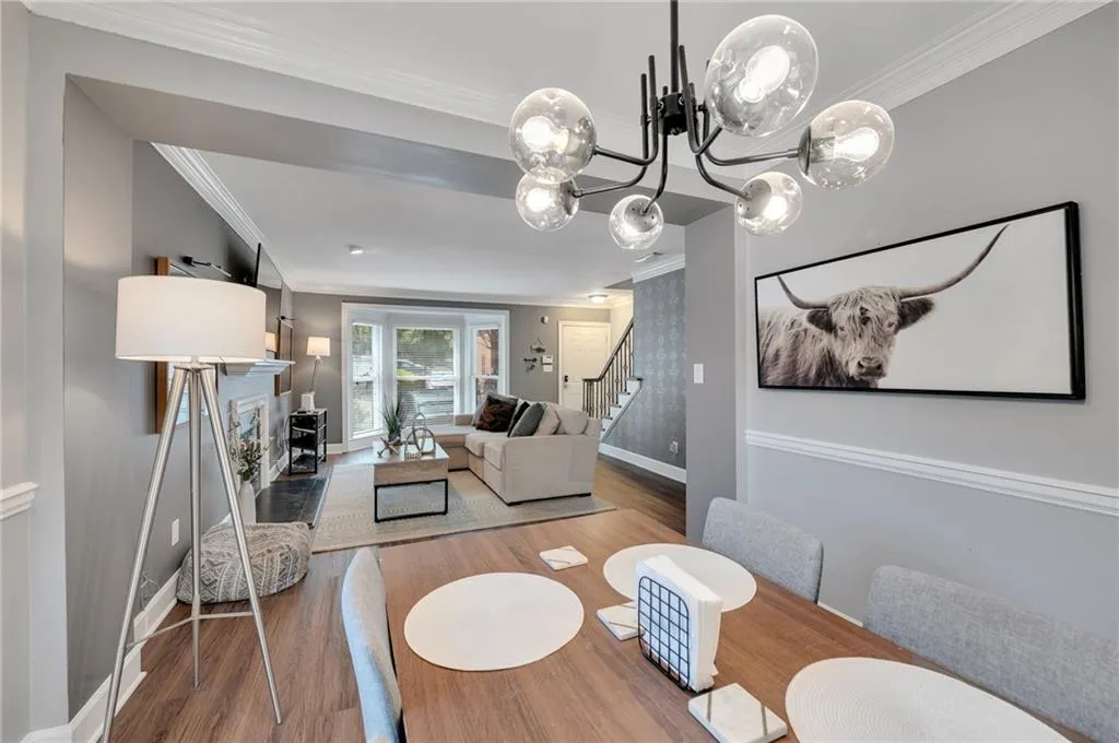Dining area with ornamental molding, dark wood-type flooring, and a chandelier