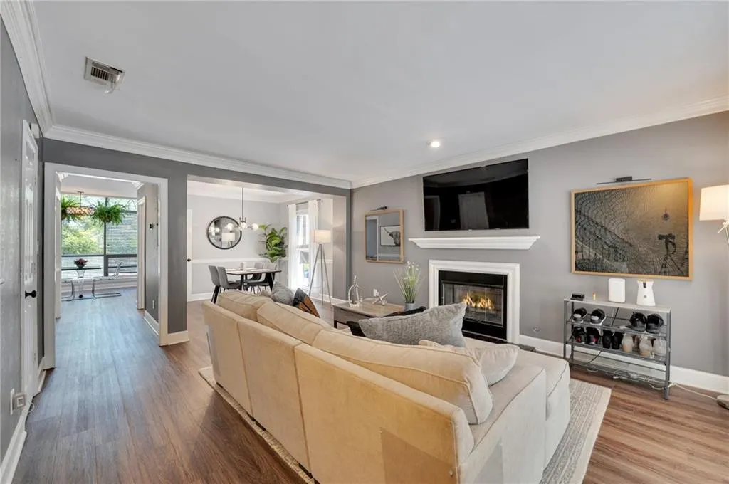 Living room featuring crown molding, a chandelier, and hardwood / wood-style flooring