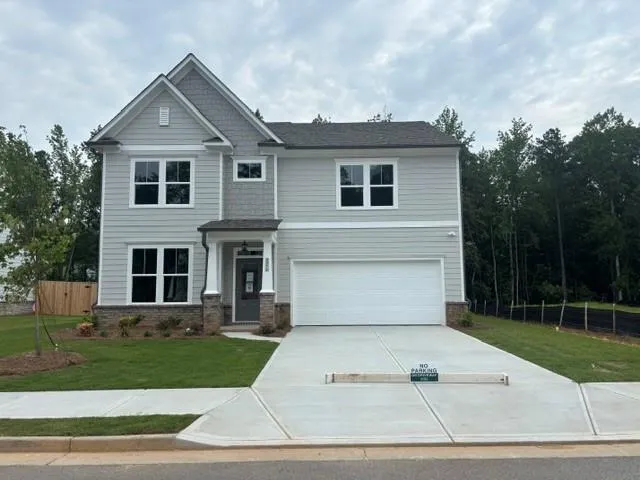 Two-story residence featuring light gray siding, stone accents, and a prominent front entry with white columns