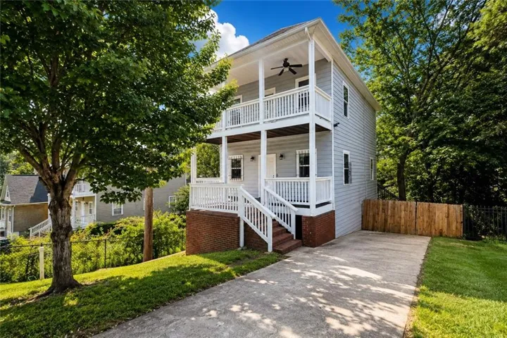 Two-story residence featuring light gray siding with white trim