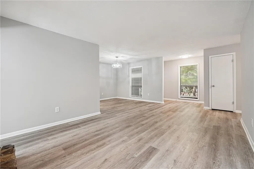 Unfurnished living room featuring light hardwood / wood-style flooring and a notable chandelier