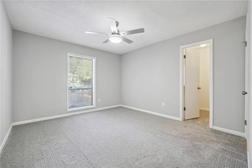 Unfurnished room with light carpet, ceiling fan, and a textured ceiling