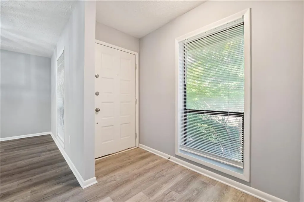 Entryway featuring a healthy amount of sunlight, a textured ceiling, and light hardwood / wood-style floors
