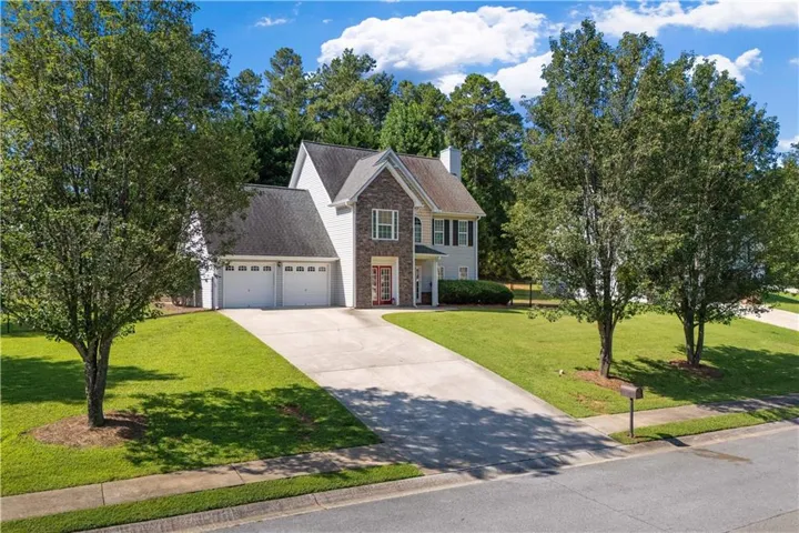 Two-story residence featuring a partial brick facade, a two-car garage, and a concrete driveway