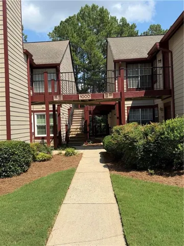 Two-story exterior with horizontal siding, a gabled roof, and a prominent exterior staircase with metal railings