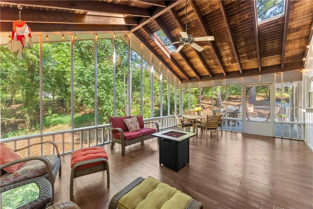 Sunroom / solarium with ceiling fan, a skylight, and an outdoor living space with a fire pit
