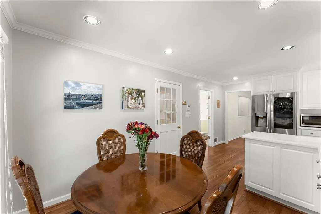 Dining area with crown molding, dark wood-style floors, and recessed lighting