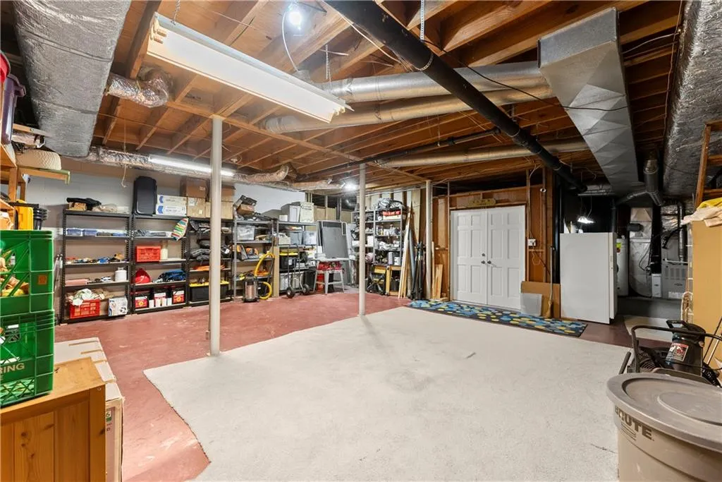 Unfinished below grade area featuring heating unit
