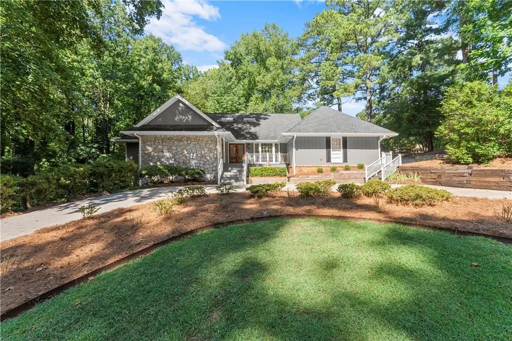 Single story home featuring a porch and stone siding