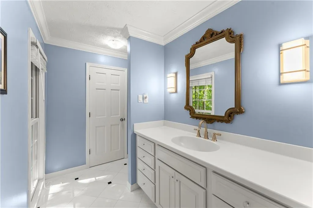 Bathroom featuring vanity, tile patterned floors, crown molding, and a textured ceiling
