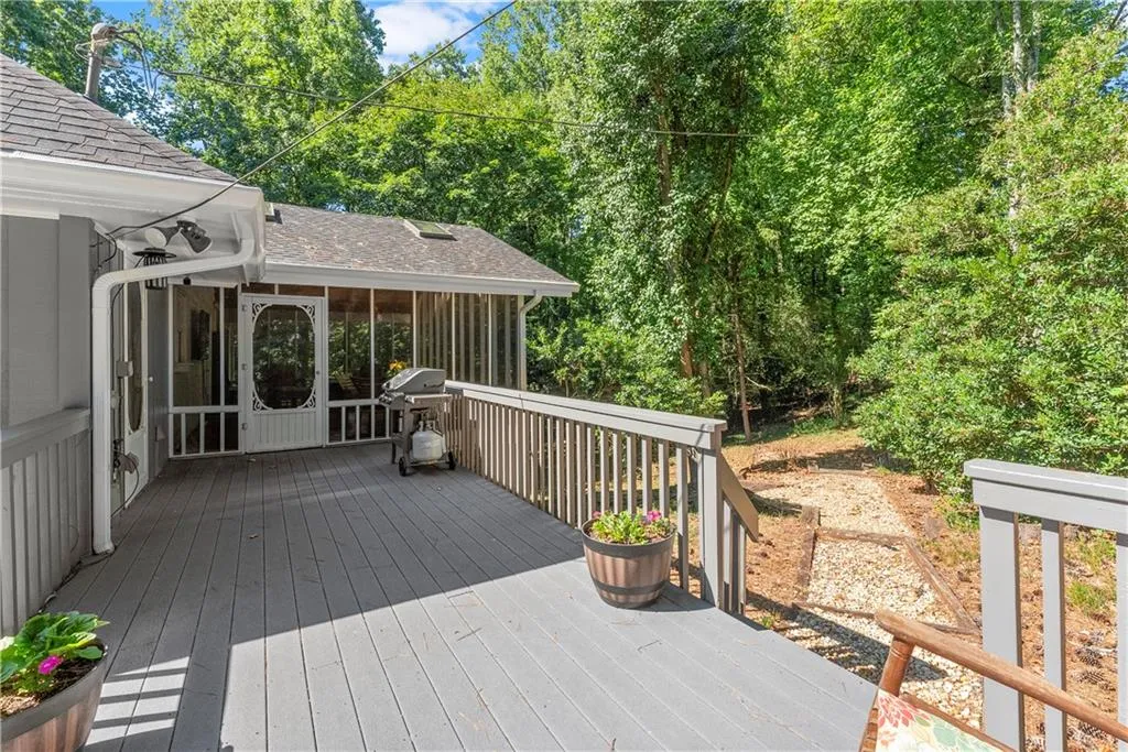 Wooden terrace featuring a sunroom and grilling area
