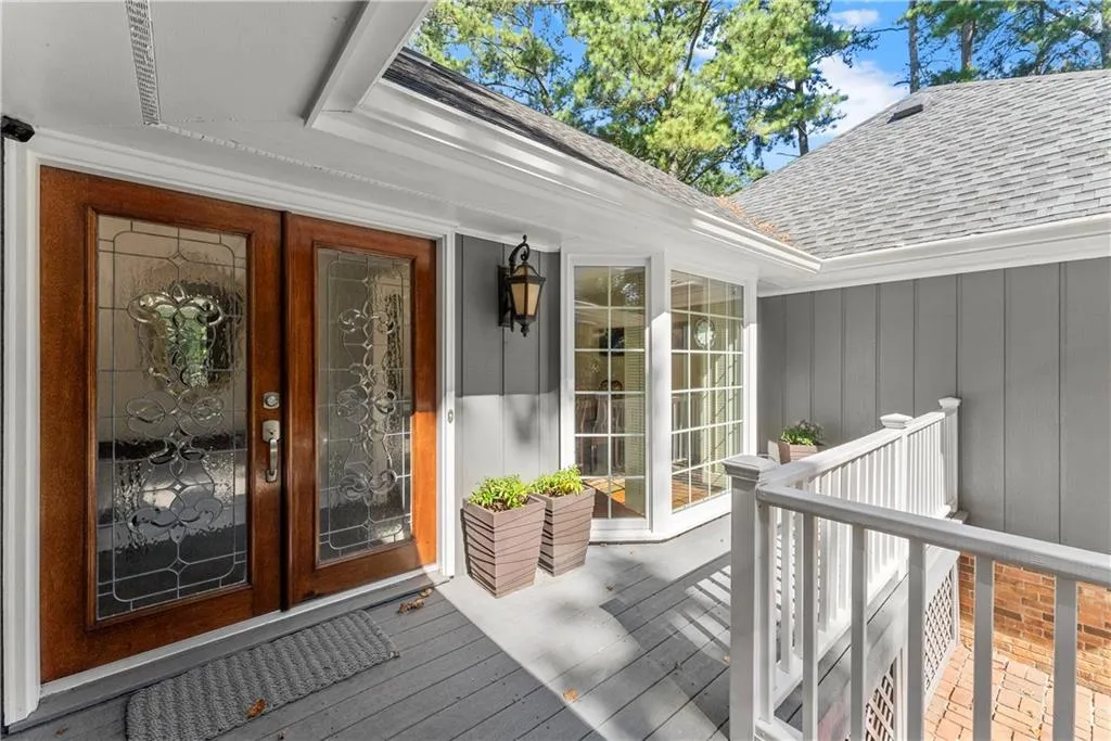 Property entrance featuring a shingled roof, board and batten siding, and french doors