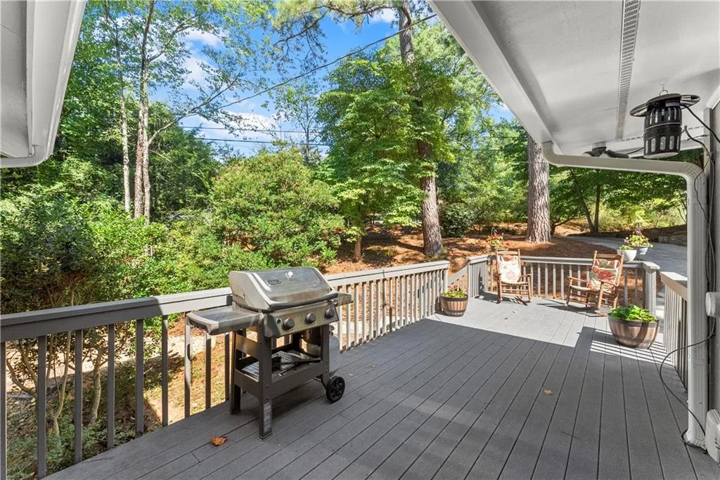 Wooden deck featuring a grill and view of wooded area