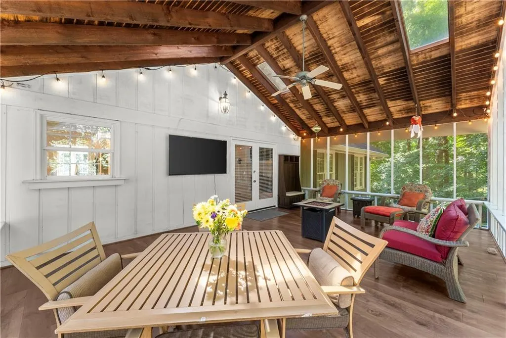 Sunroom with a ceiling fan, outdoor dining area, an outdoor fire pit, and french doors