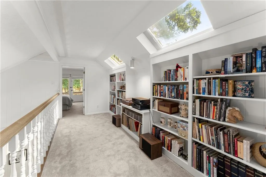 Living area with a skylight and carpet