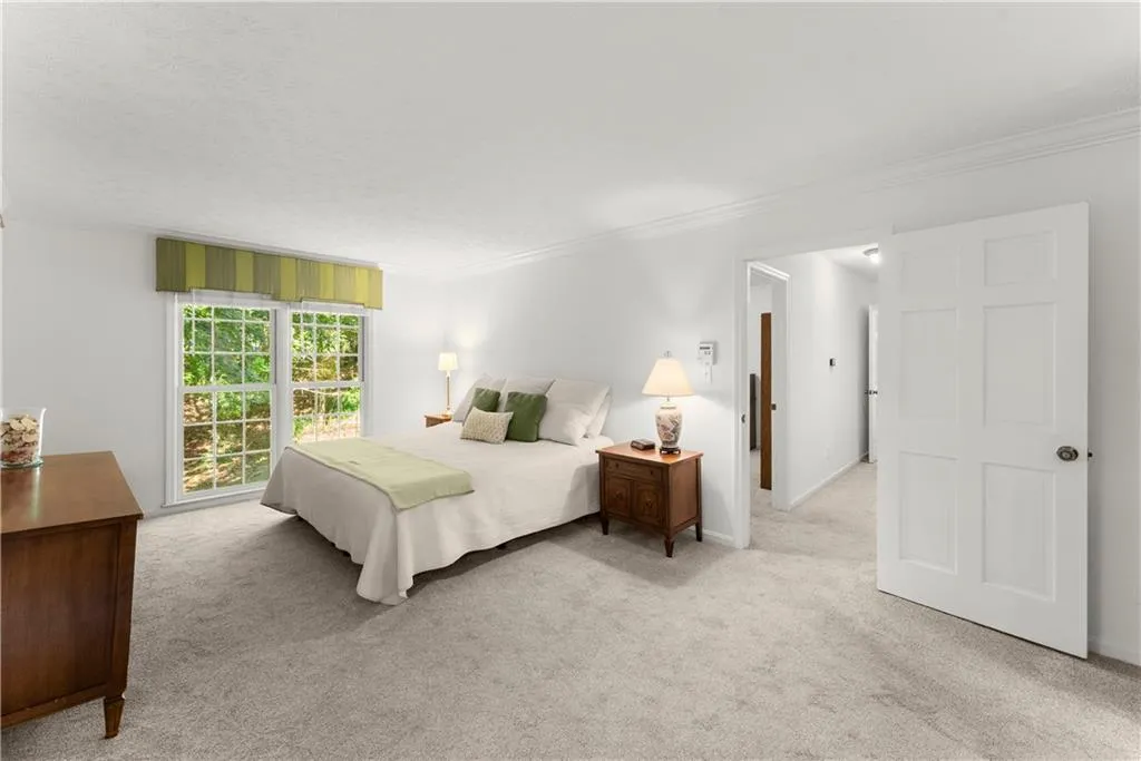 Carpeted bedroom featuring crown molding and baseboards