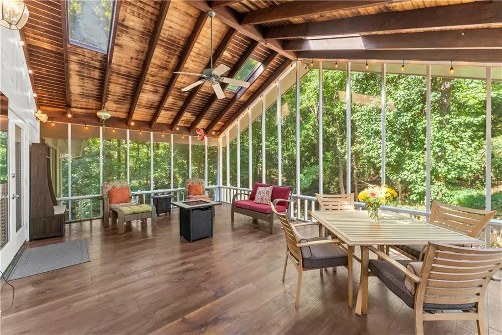 Sunroom / solarium with a ceiling fan, outdoor dining area, and an outdoor living space with a fire pit