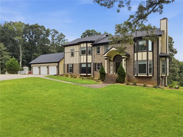 Brick and stucco exterior with a prominent two-story bay window