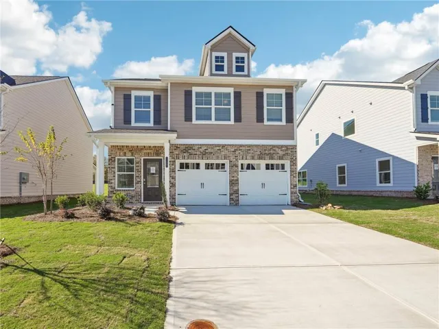 Craftsman-style house featuring brick siding, a front lawn, concrete driveway, and a garage