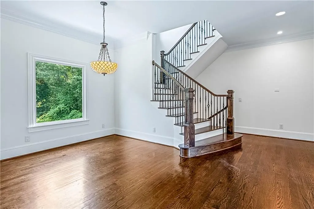 Stairway with ornamental molding and wood finished floors