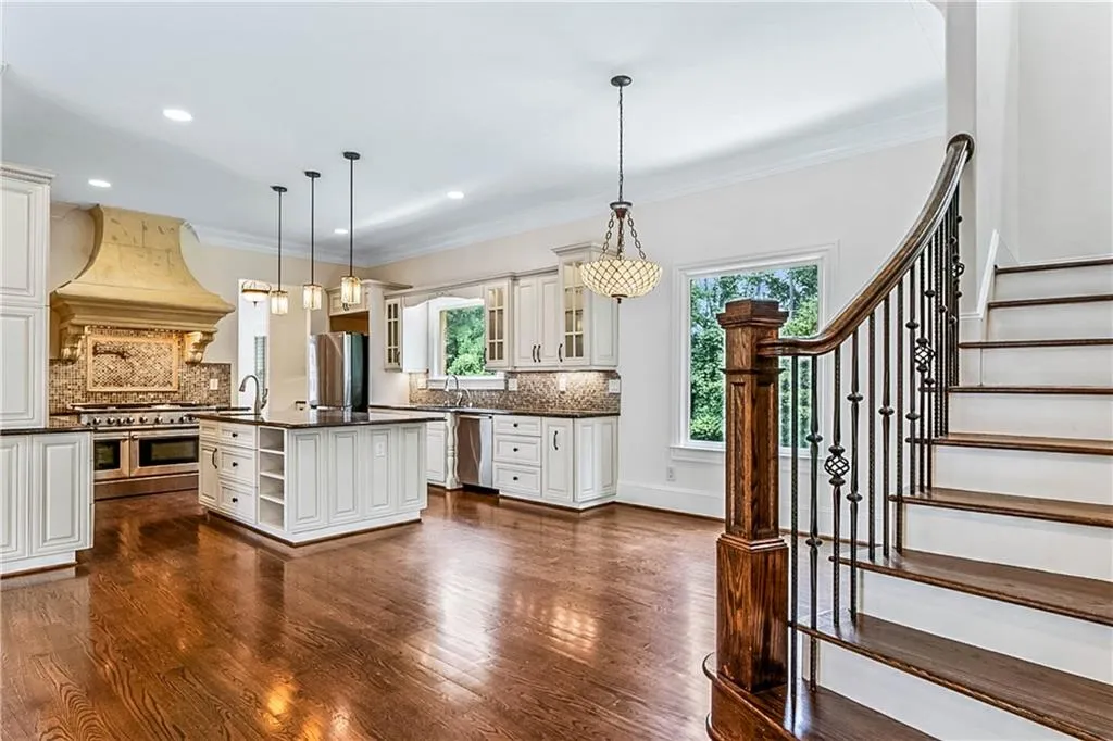 Kitchen featuring backsplash, open shelves, ornamental molding, decorative light fixtures, and dark wood-style floors