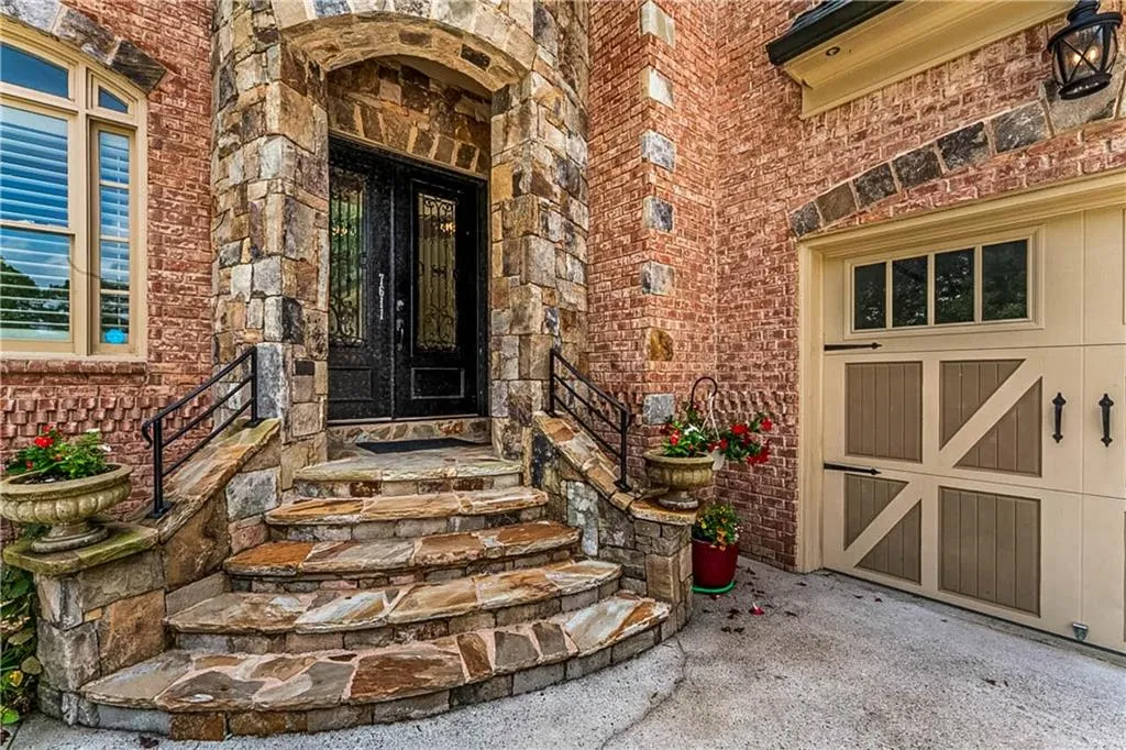 View of exterior entry with brick siding and stone siding