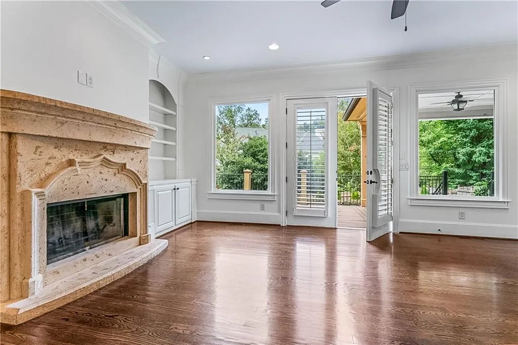 Unfurnished living room with ornamental molding, dark wood-style flooring, built in features, a premium fireplace, and recessed lighting