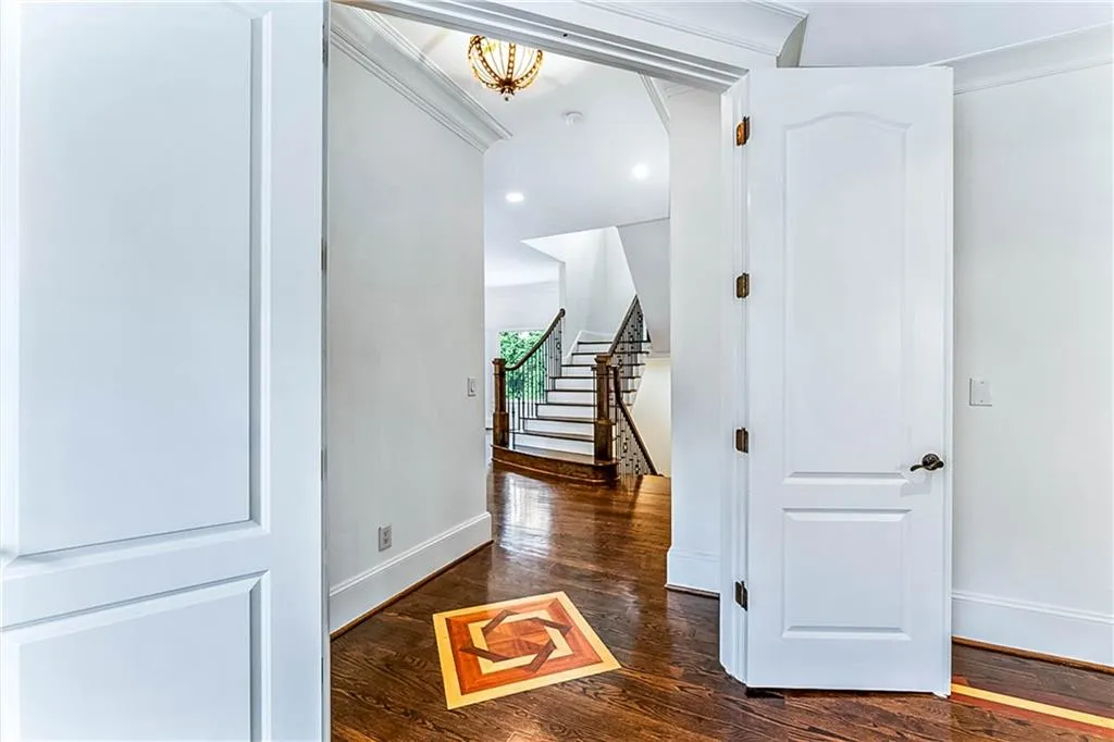Hallway with dark wood-type flooring, recessed lighting, a chandelier, and arched walkways