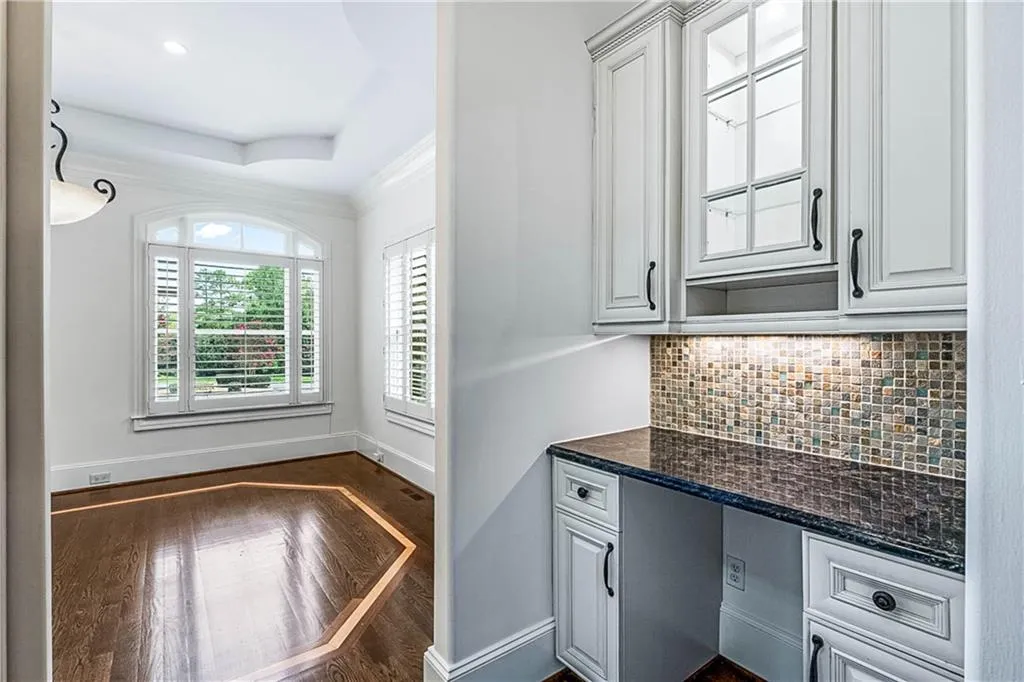 Unfurnished office featuring dark wood-style floors, crown molding, and a raised ceiling