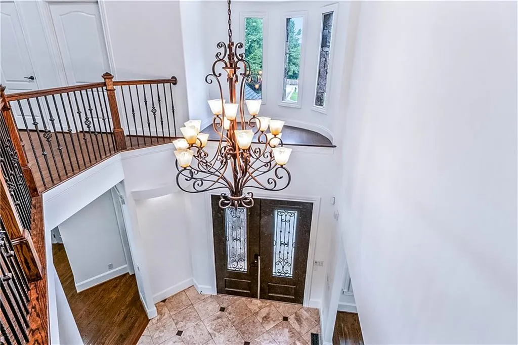 Entrance foyer featuring a chandelier, french doors, a high ceiling, and wood finished floors