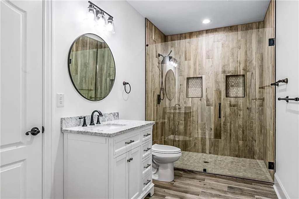 Bathroom with a stall shower, vanity, and wood tiled floors