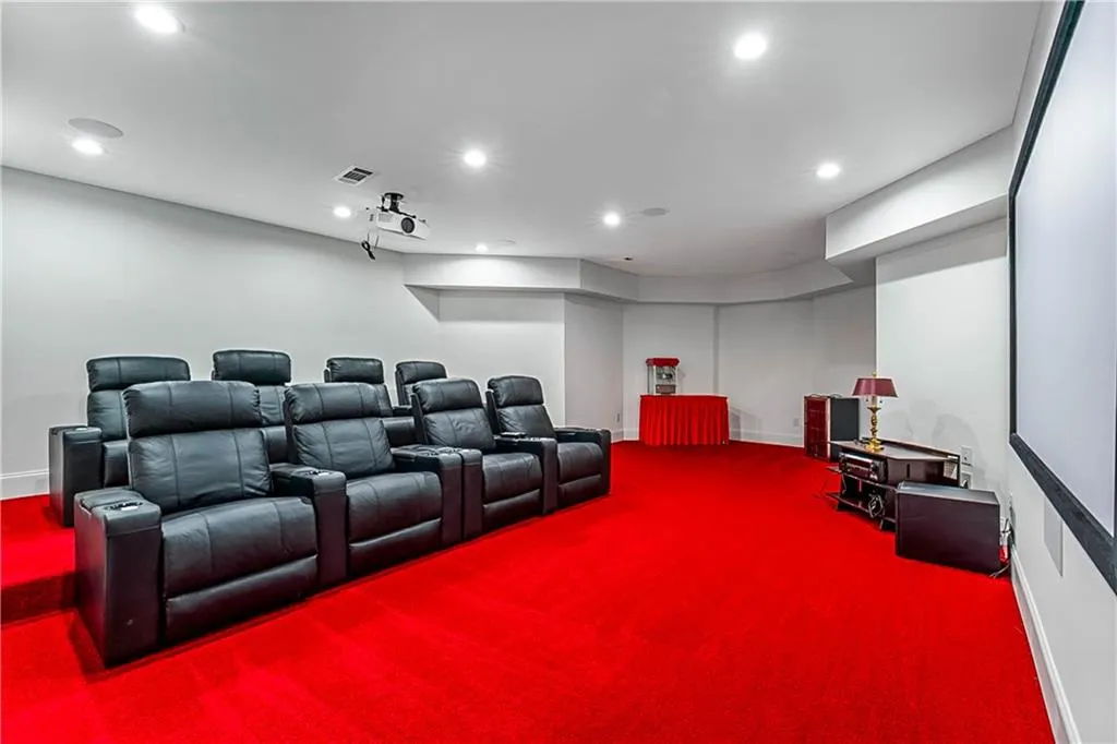 Luxury home theater with recessed lighting and baseboards