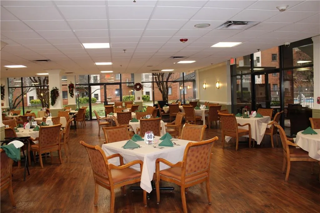 Dining room featuring floor to ceiling windows, a healthy amount of sunlight, and wood-type flooring
