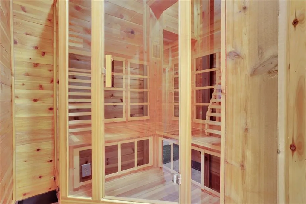 Dry Sauna (sub basement level) with wood walls and hardwood / wood-style flooring