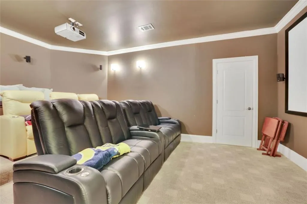 Cinema with light carpet and crown molding. Wall sconces with dimmers