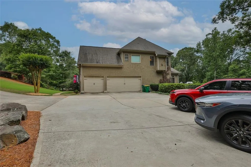 View of side of home with a 3 car garage and ample parking pad