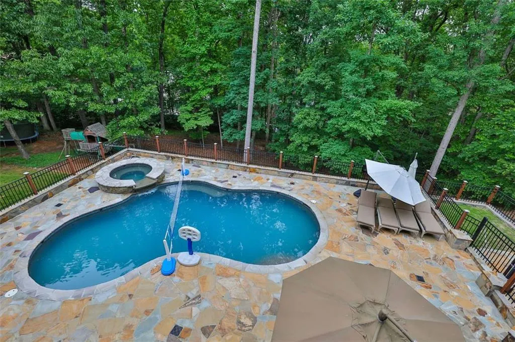 View of pool with a patio area and an in ground hot tub