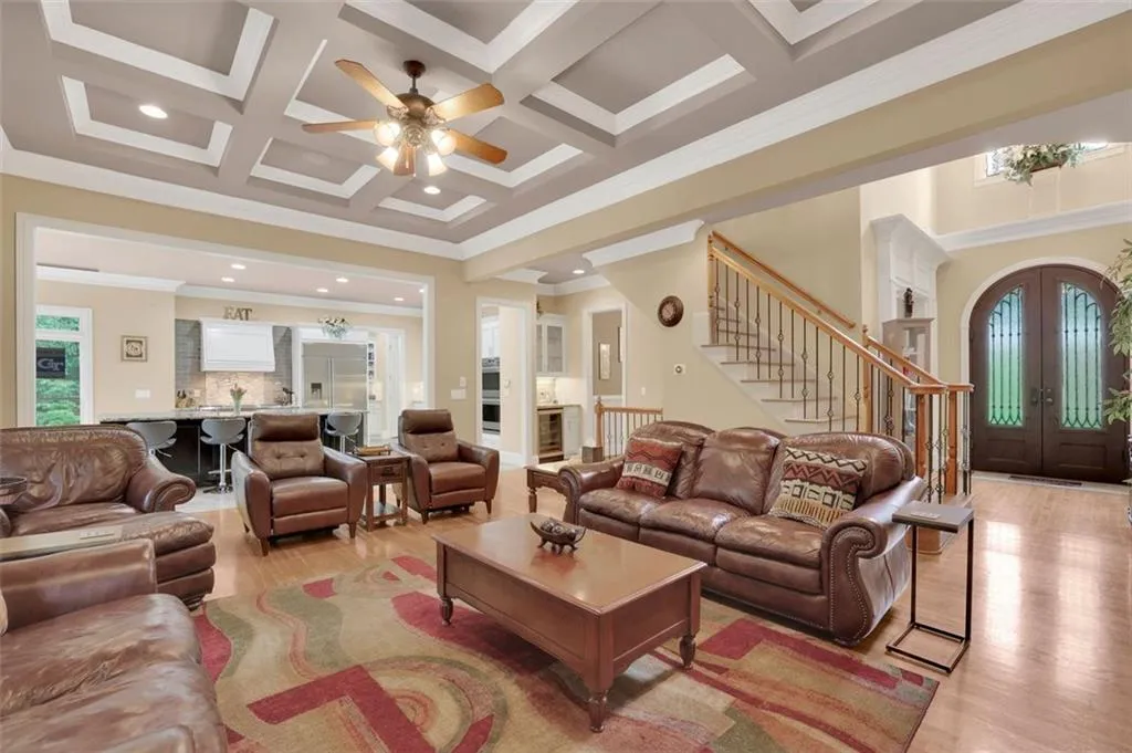 Family room featuring french doors, crown molding, coffered ceiling, and light hardwood / wood-style floors