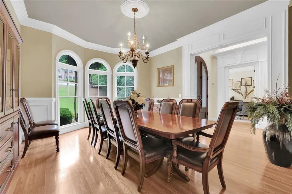 Formal Dining room with ornamental molding, a notable chandelier, and light hardwood / wood-style flooring